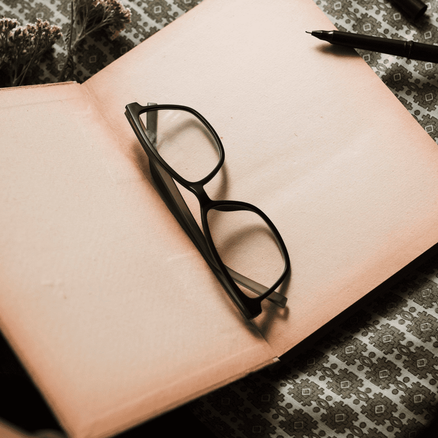Un paio di occhiali da vista neri dentro un libro aperto. - Crisafulli Eyewear a Milano